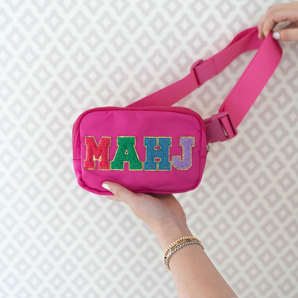 Hot pink belt bag with "MAHJ" written on it